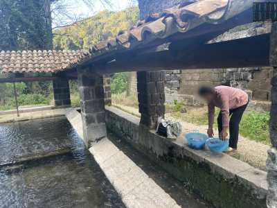 Fanno diversi viaggi su e gi� per la scarpata portando tutto l�occorrente al lavaggio, quindi sciacquano le pietre del lavatoio e iniziano a strofinare i capi